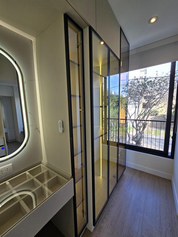 Vestidor de vidrio con tocador y espejo iluminado