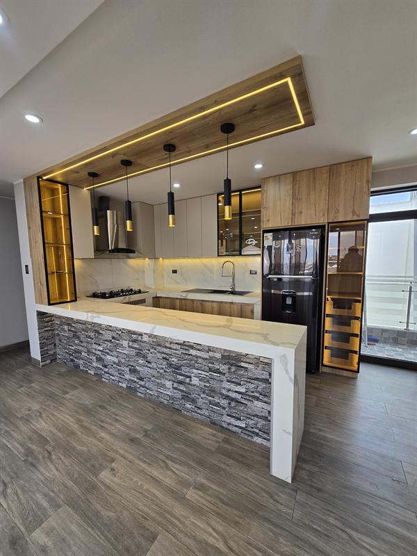 Cocina con isla y techo de madera iluminado