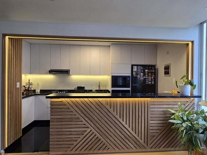 Cocina con barra revestida de listones e iluminación LED