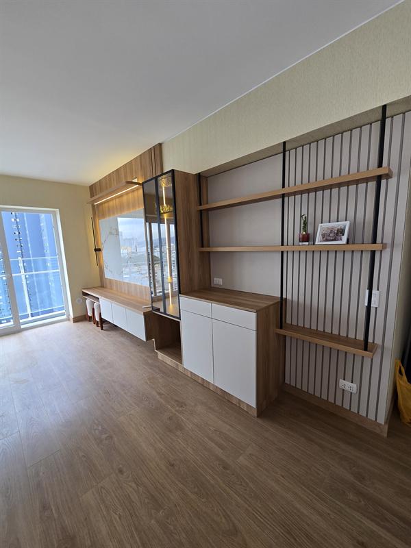 Sala con muebles bajos, vitrina y repisas de madera